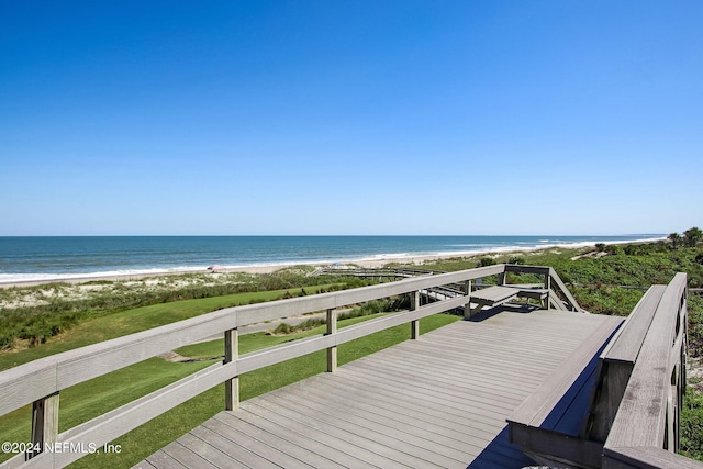 wooden deck with a water view and a beach view