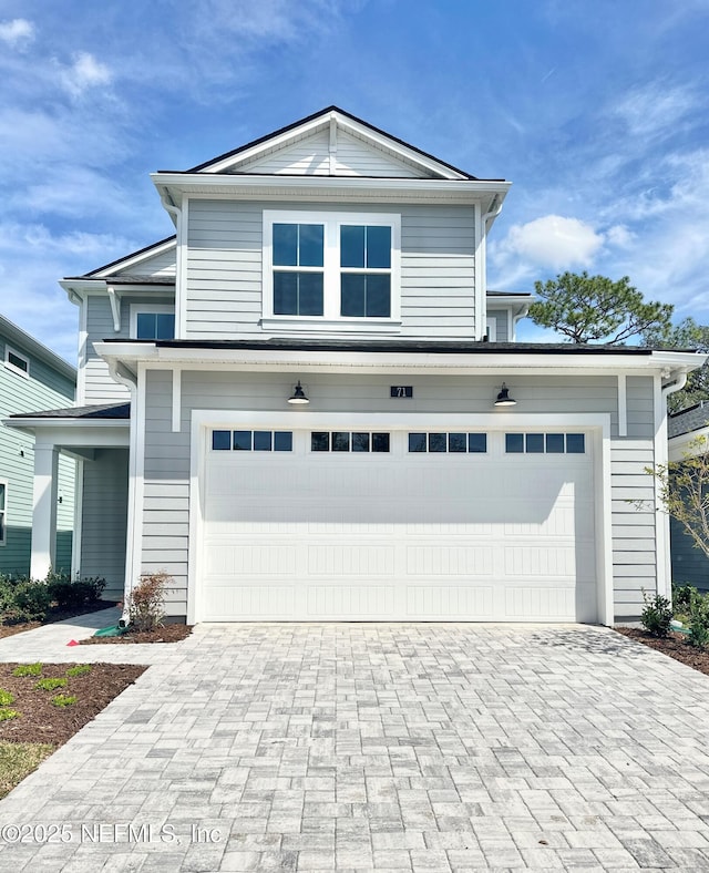 traditional-style home with decorative driveway and an attached garage