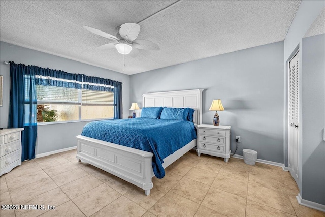 tiled bedroom featuring a textured ceiling, ceiling fan, and a closet