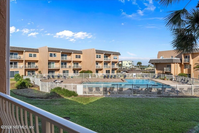 view of pool with a lawn