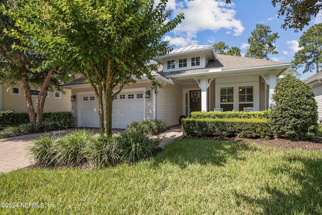 view of front of property featuring a garage, a front lawn, and decorative driveway