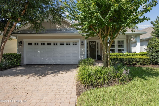 view of front of home featuring an attached garage and decorative driveway