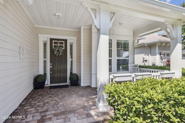 entrance to property featuring covered porch and a garage