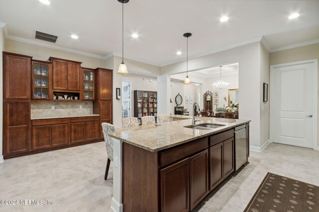 kitchen featuring sink, decorative light fixtures, light tile patterned floors, a kitchen breakfast bar, and dishwasher