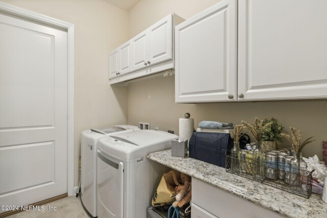 laundry area with washing machine and clothes dryer and cabinets