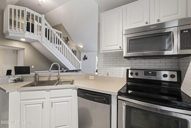 kitchen with tasteful backsplash, appliances with stainless steel finishes, sink, and white cabinets