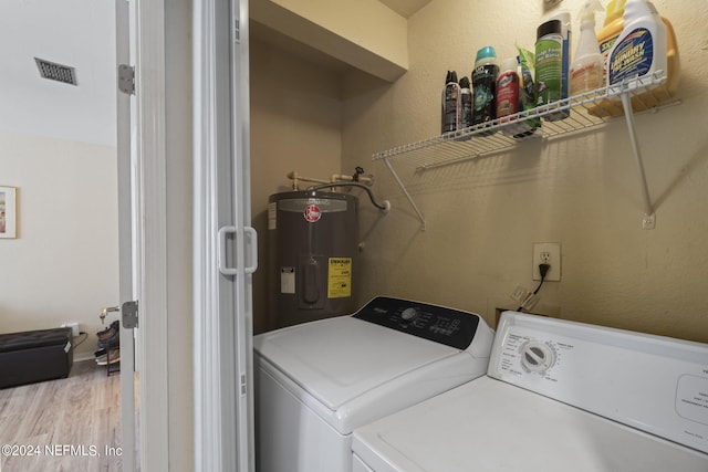 laundry room featuring water heater, independent washer and dryer, and light hardwood / wood-style flooring