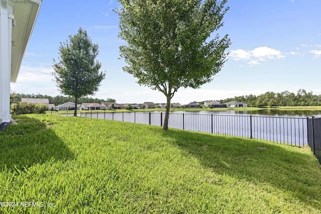 view of yard featuring a water view and fence