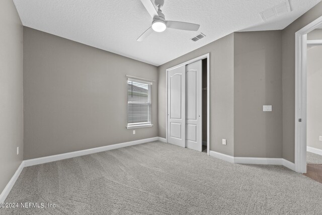 unfurnished bedroom with carpet floors, baseboards, visible vents, and a closet