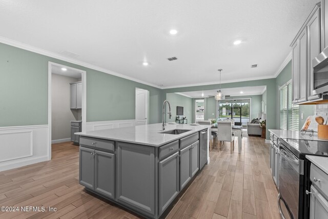 kitchen featuring range with electric stovetop, gray cabinets, stainless steel dishwasher, open floor plan, and a sink