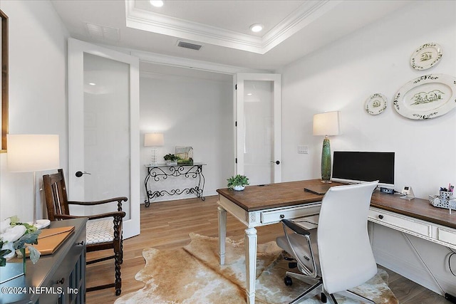 home office featuring a tray ceiling, crown molding, recessed lighting, visible vents, and light wood-style flooring