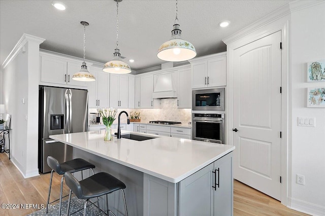 kitchen featuring light countertops, appliances with stainless steel finishes, a sink, and white cabinetry