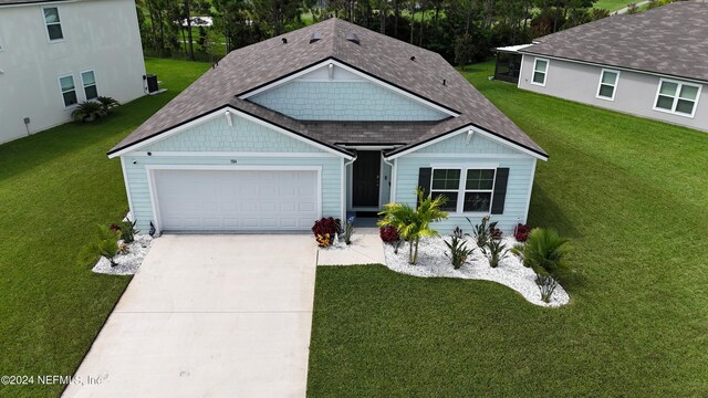 single story home with a garage and a front lawn