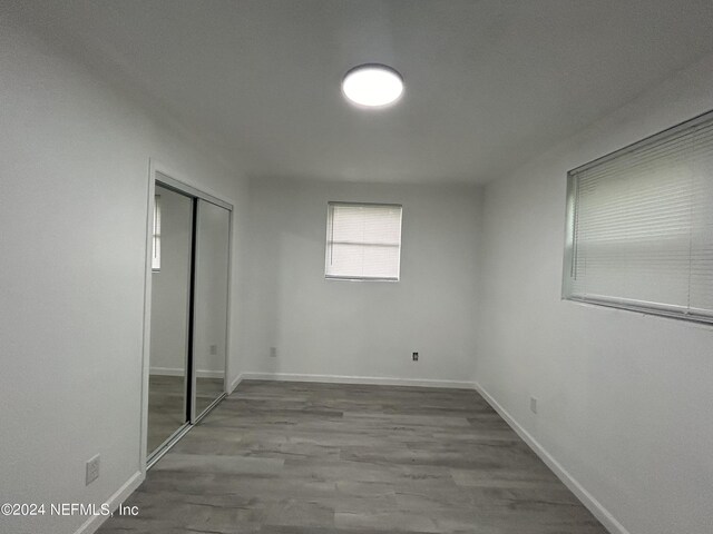 unfurnished bedroom featuring wood-type flooring and a closet