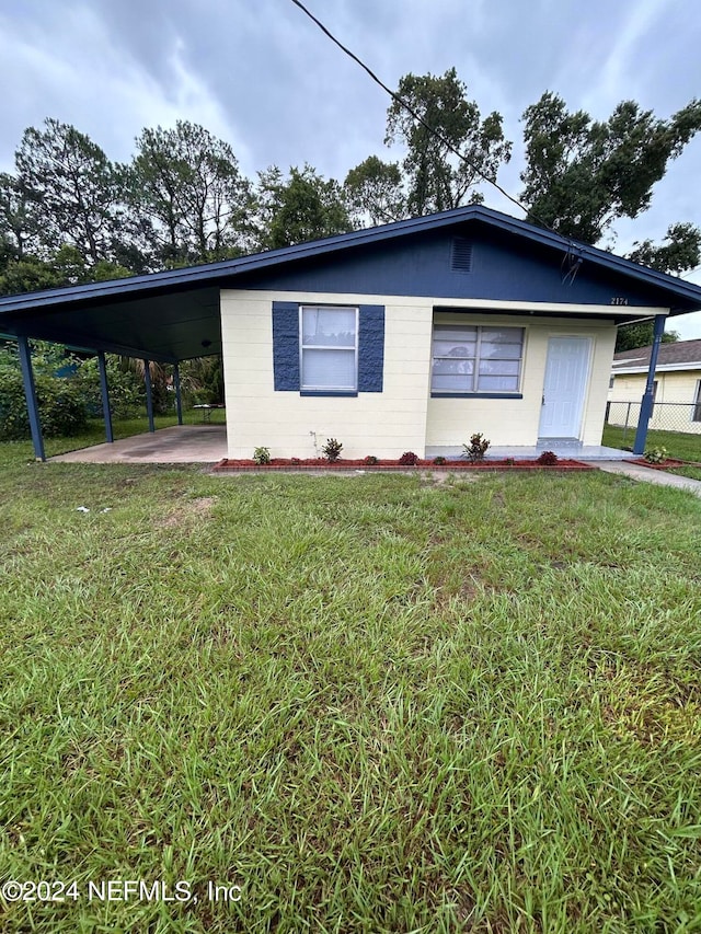 view of front of house featuring a front lawn and a carport