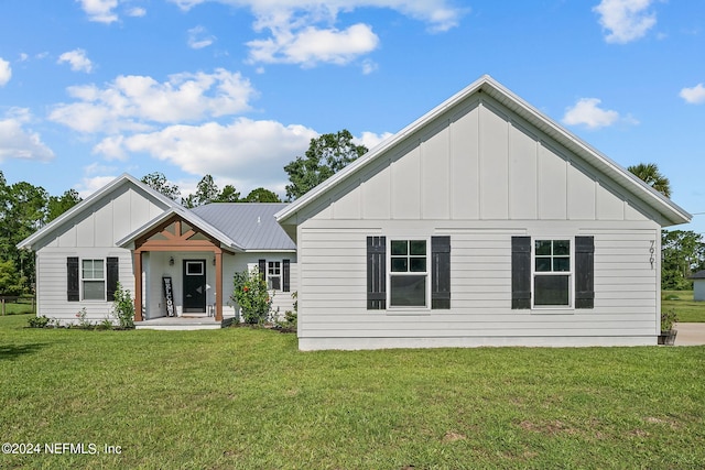 view of front of property with metal roof, board and batten siding, and a front yard