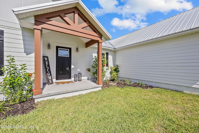 property entrance featuring metal roof and a yard