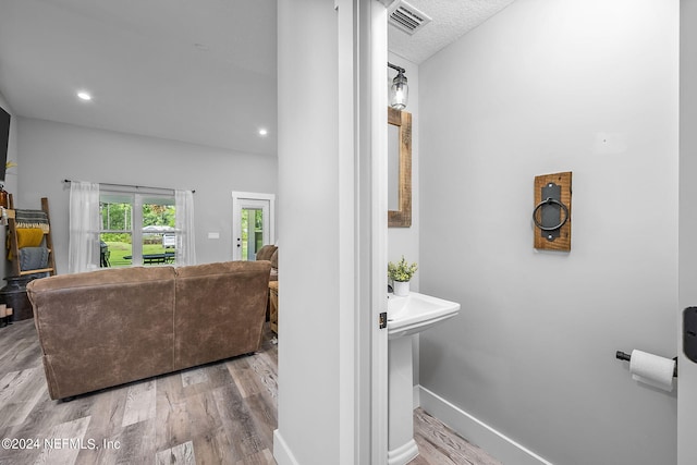 living room with recessed lighting, visible vents, baseboards, and wood finished floors