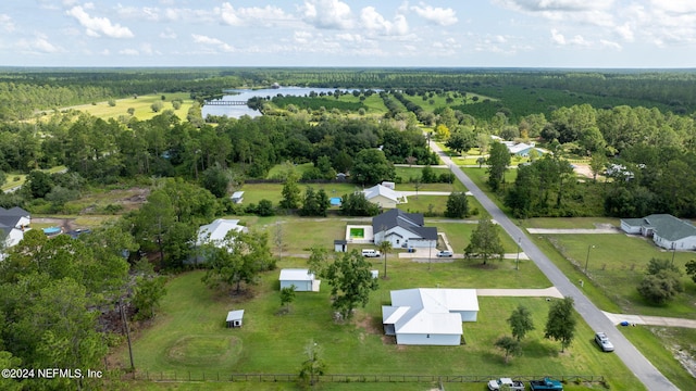 birds eye view of property with a water view and a view of trees