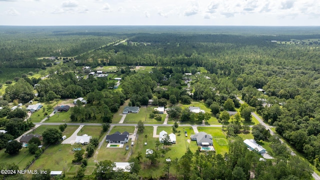 drone / aerial view featuring a wooded view