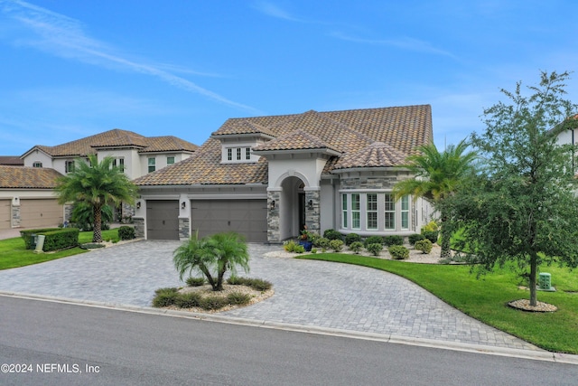 mediterranean / spanish-style house featuring a garage and a front lawn