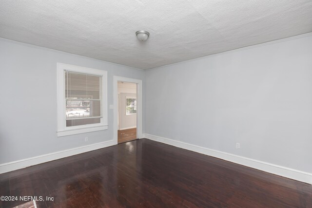 empty room with a textured ceiling and hardwood / wood-style floors