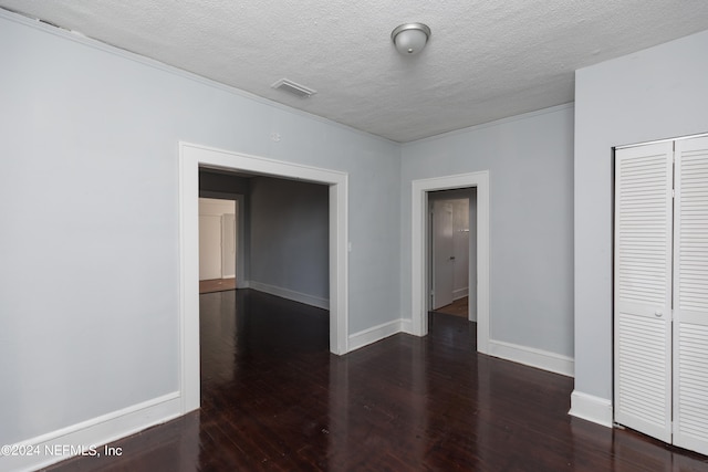 spare room with a textured ceiling and dark hardwood / wood-style flooring