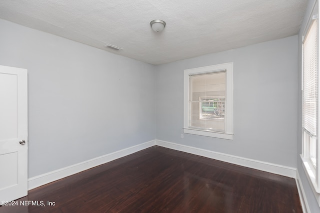 spare room with a textured ceiling and wood-type flooring