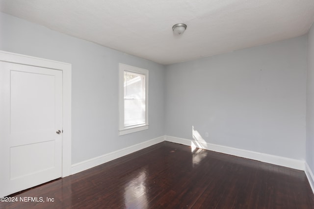 spare room with a textured ceiling and hardwood / wood-style flooring