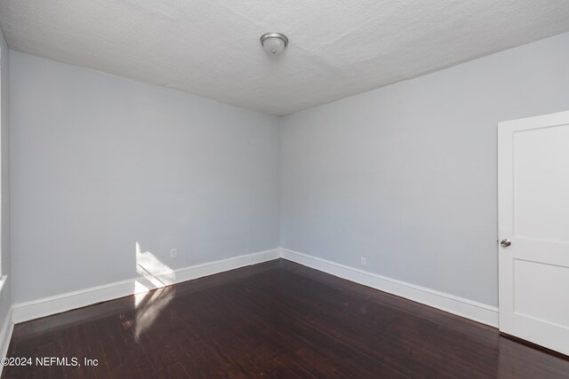 unfurnished room with a textured ceiling and hardwood / wood-style floors