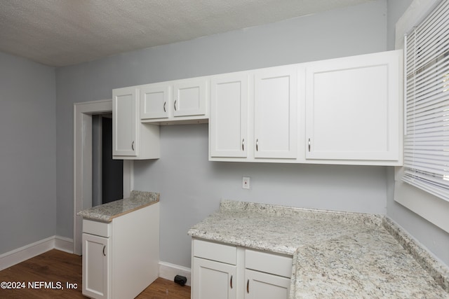 kitchen featuring dark hardwood / wood-style flooring and white cabinets