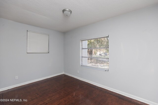 empty room featuring a textured ceiling and hardwood / wood-style flooring