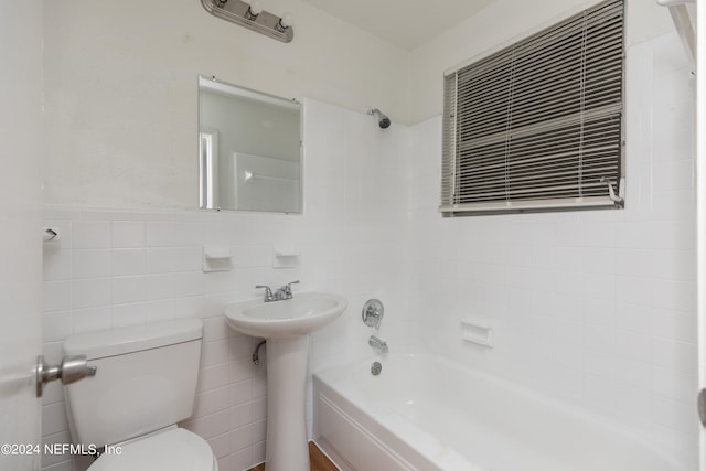 full bathroom featuring tile walls, toilet, sink, and bathtub / shower combination