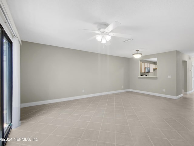 spare room with ceiling fan and light tile patterned floors