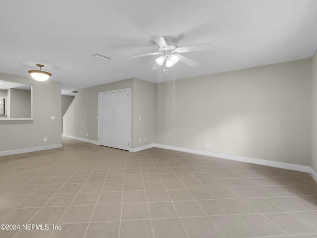 tiled empty room with a textured ceiling and ceiling fan