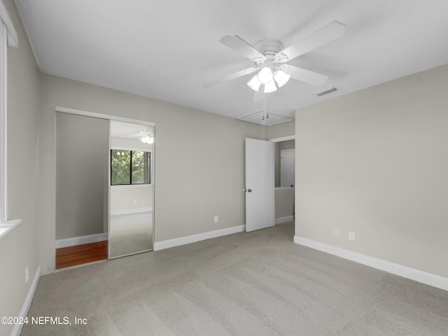 unfurnished bedroom with light colored carpet and ceiling fan