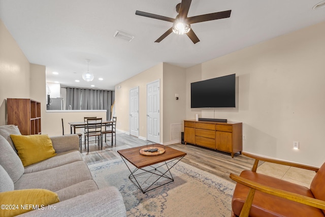 living room featuring light hardwood / wood-style floors and ceiling fan