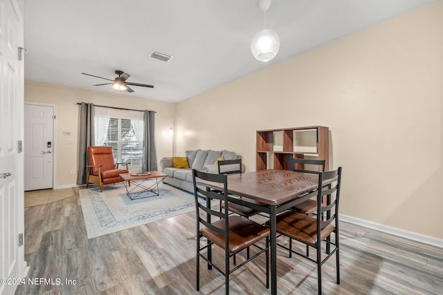 dining space with wood-type flooring and ceiling fan