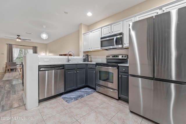 kitchen featuring white cabinets, ceiling fan, appliances with stainless steel finishes, and gray cabinetry