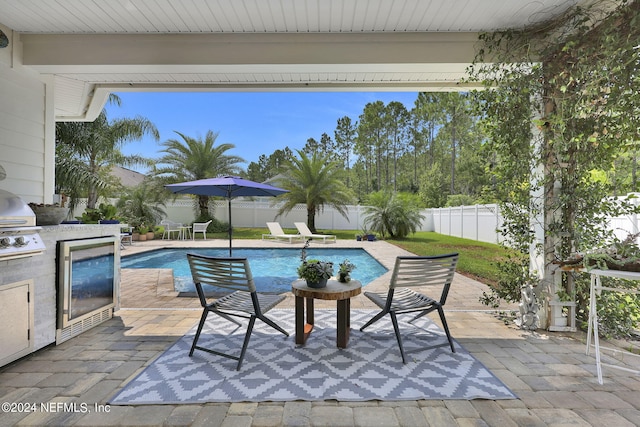 view of pool featuring area for grilling, a grill, and a patio area