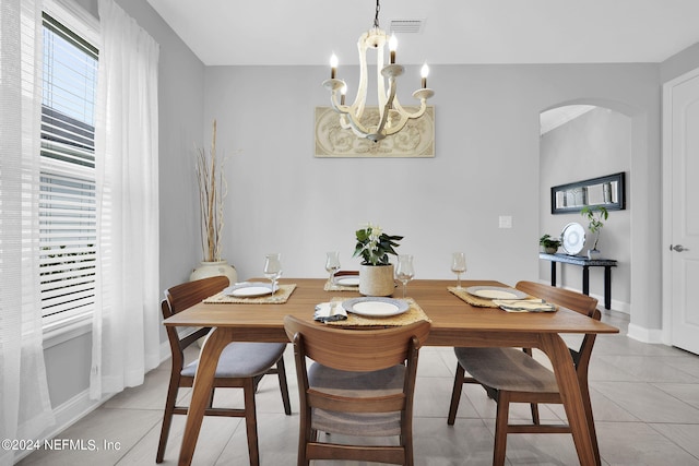 tiled dining room with an inviting chandelier