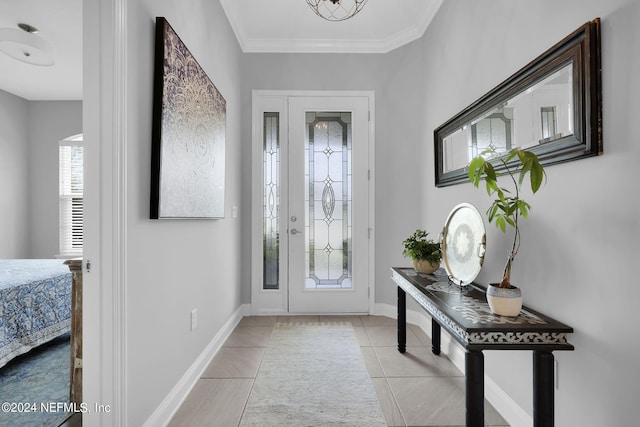 entrance foyer with light tile patterned floors and ornamental molding