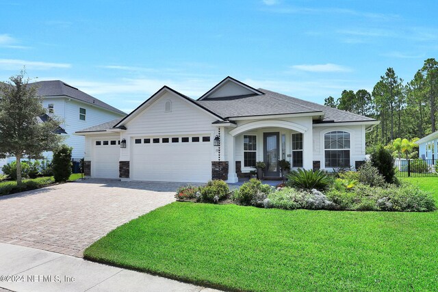 view of front of property featuring a front lawn and a garage