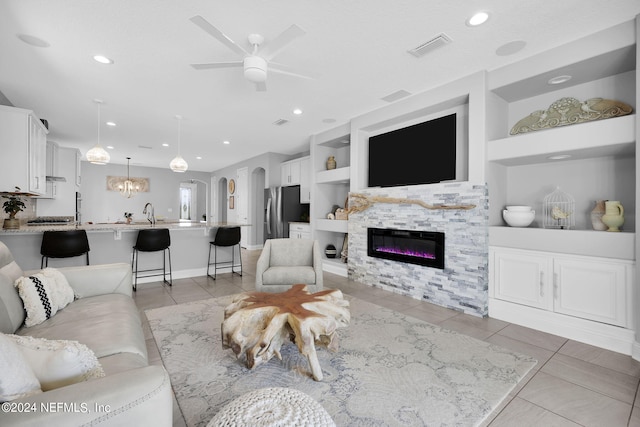 tiled living room with built in features and ceiling fan