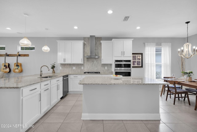 kitchen featuring sink, white cabinets, kitchen peninsula, stainless steel appliances, and wall chimney exhaust hood