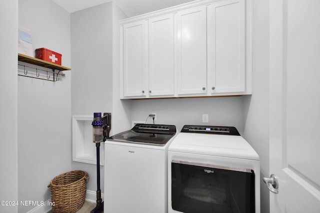 washroom featuring cabinets and washing machine and dryer