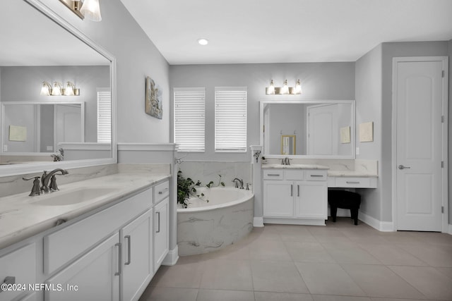 bathroom featuring tiled tub, vanity, and tile patterned flooring