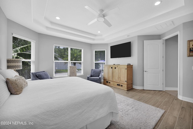 bedroom with a raised ceiling and ceiling fan