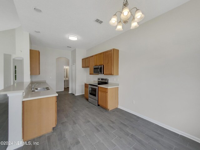 kitchen featuring an inviting chandelier, sink, stainless steel appliances, and hardwood / wood-style floors