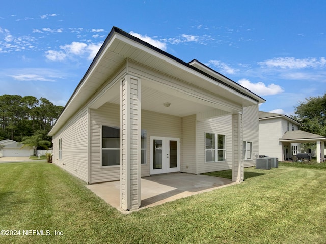 back of house featuring cooling unit, a lawn, and a patio area